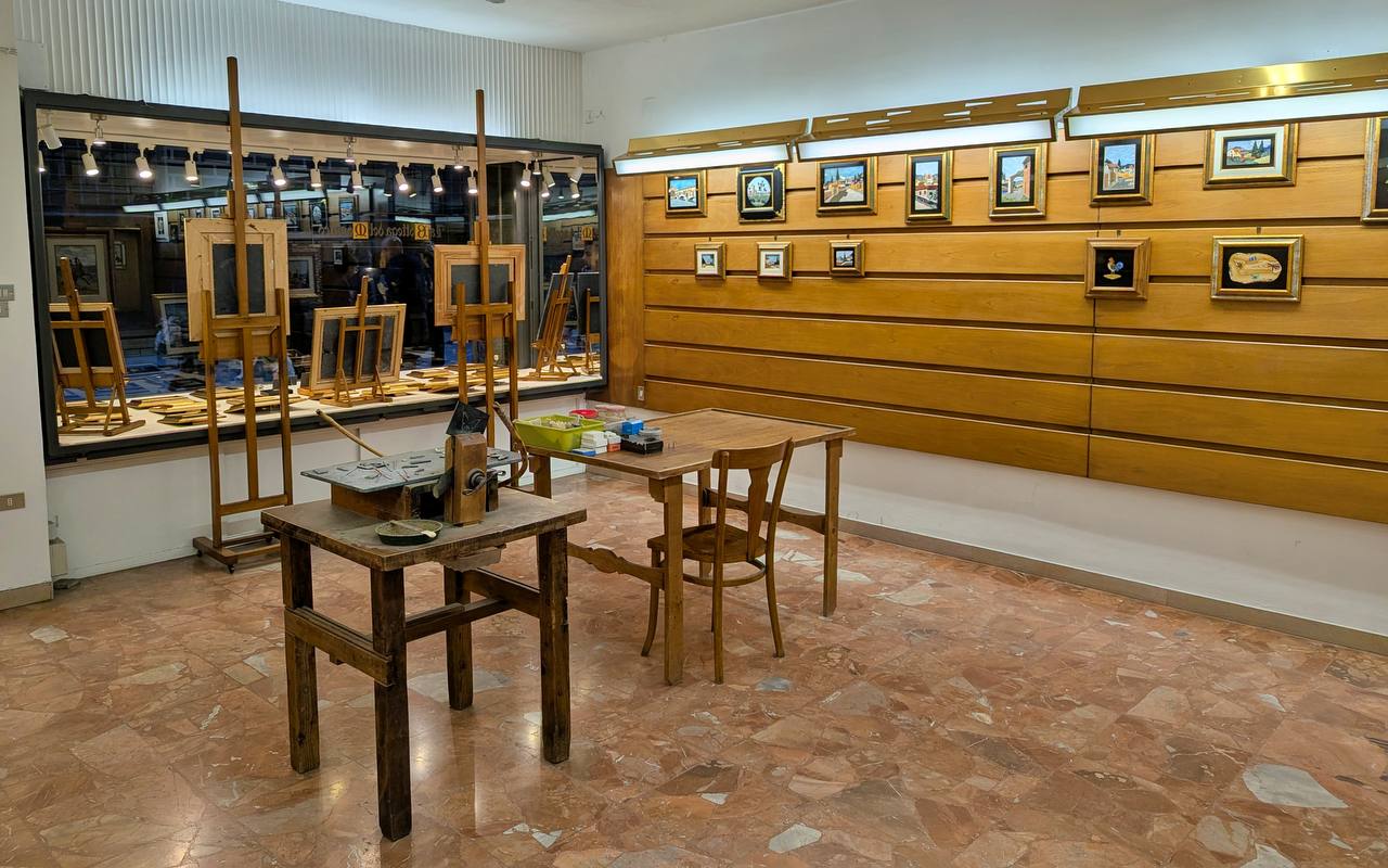 Interior of La Bottega del Mosaico workshop with workbench and mosaic panels